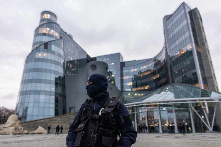 Petugas dari kepolisian berdiri di depan markas besar TV Publik Polandia di Warsawa (foto: Dok IFJ, sumber: Wojtek Radwanski/AFP)