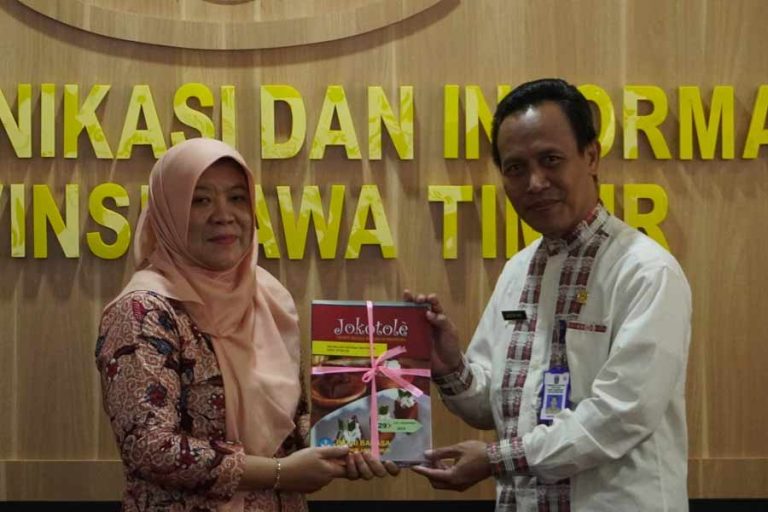 Umi Kulsum (kiri), Kepala Balai Bahasa Provinsi Jawa Timur, memberikan cindera mata pada Kabid Komunikasi Publik, Assyari (kanan) di Surabaya